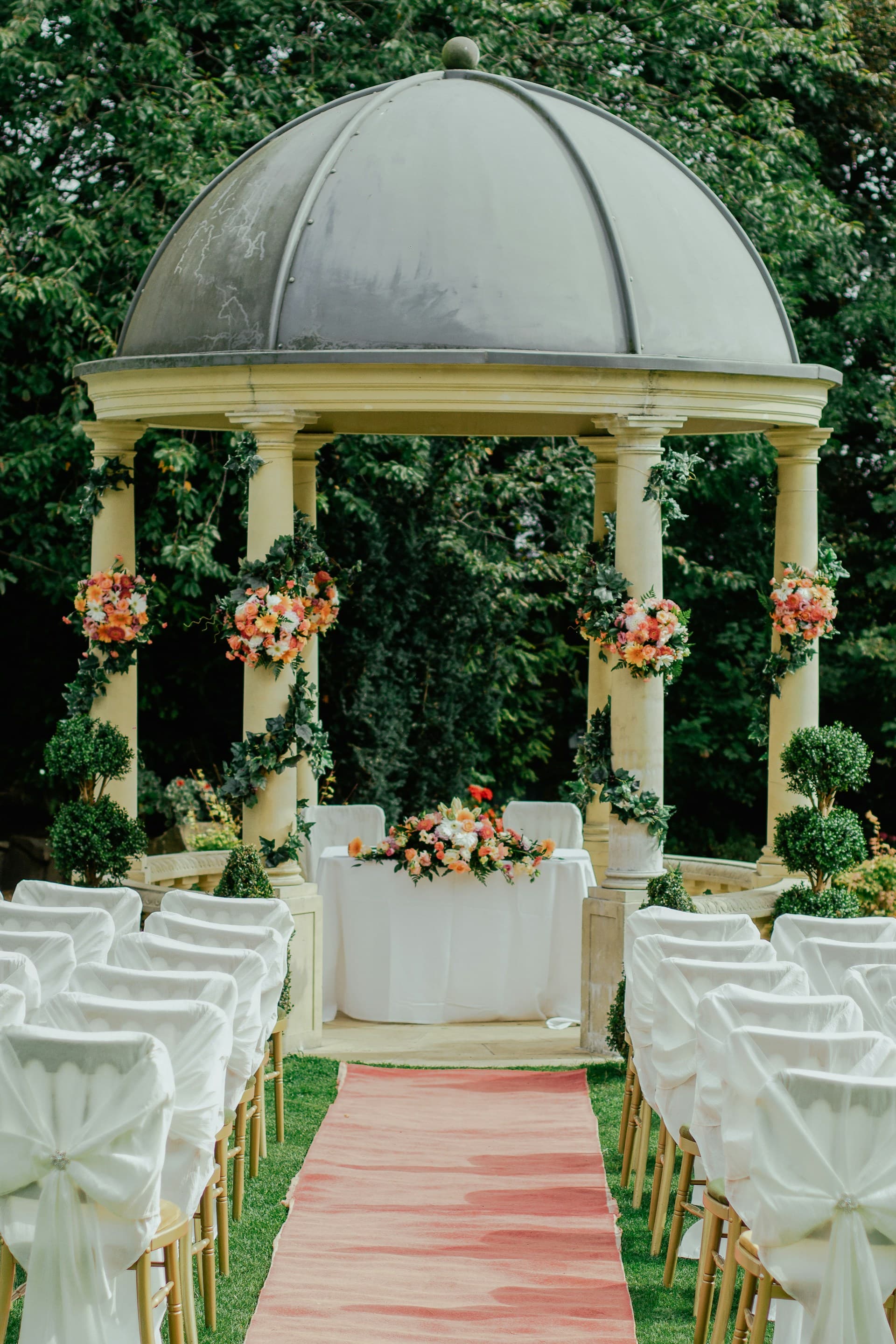 A floral pavilion and white ceremony seating outdoors